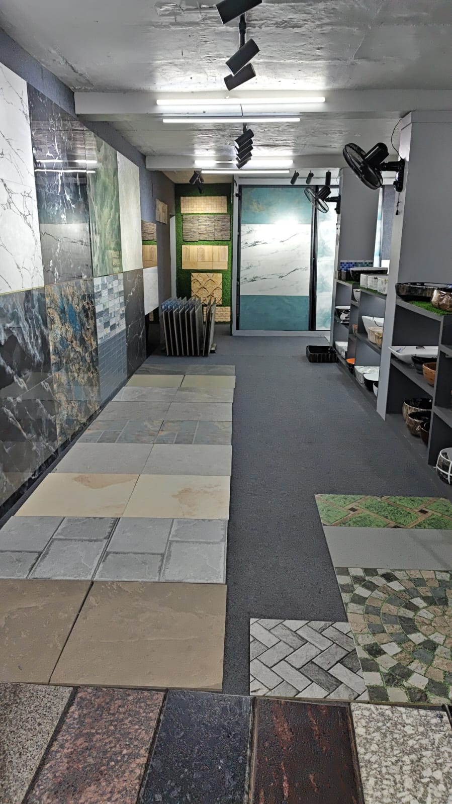 Shree Ceramic showroom aisle with wall tile displays and floor tile samples laid out